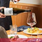 Copa de vino tinto junto a un platillo gourmet ilustrando el concepto de maridaje